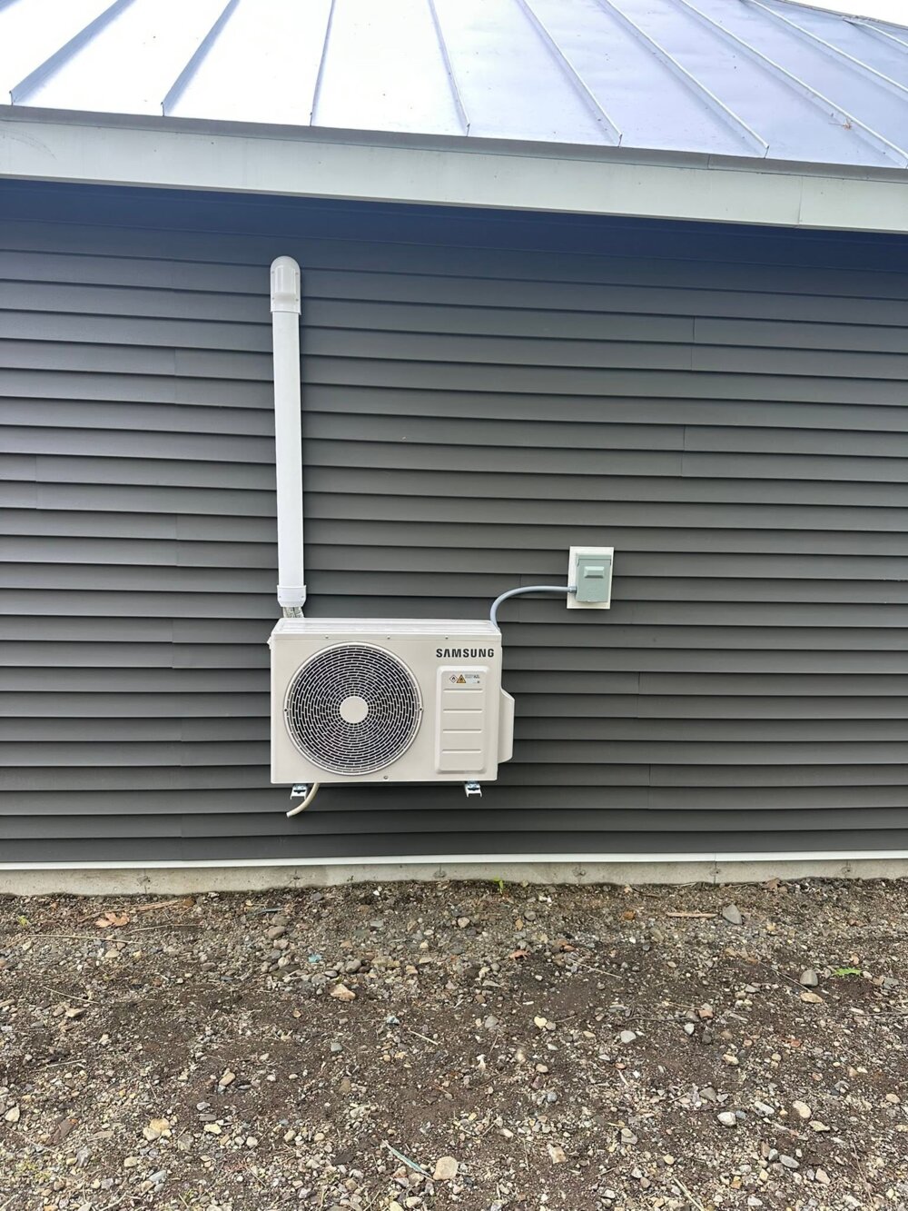 Wall-mounted Samsung outdoor heat pump with tidy line-set cover — Barnett Heat Pumps