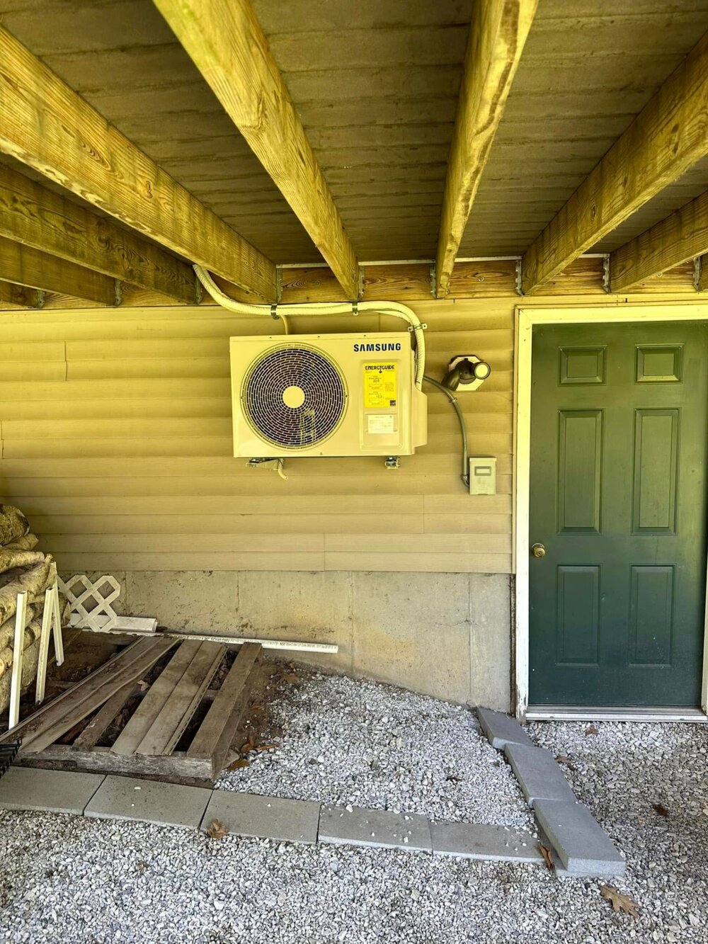Samsung outdoor heat pump installed under a deck — Barnett Heat Pumps